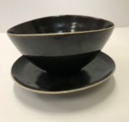 A Lucie Rie and Hans Coper black glazed elliptical bowl and saucer, both bearing both marks,