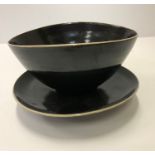 A Lucie Rie and Hans Coper black glazed elliptical bowl and saucer, both bearing both marks,