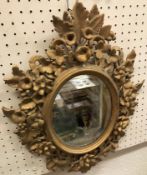 A Florentine carved giltwood and gesso oval framed wall mirror with floral and foliate decoration,