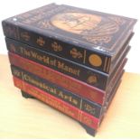 A painted box table as a pile of oversized books including "The Travels of Marco Polo",