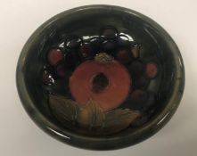 A Tudric Moorcroft pomegranate pattern pedestal bowl of small proportions the pewter base stamped