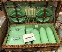 A vintage cane coracle picnic basket with Bandalasta and Thermos green plastic fittings
