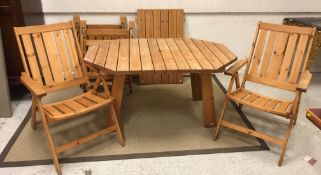 A modern slatted pine elongated octagonal garden table on splayed supports,