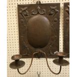 A pair of Edwardian John Pearson copper wall sconces with stylised floral decoration,