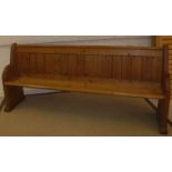 A circa 1900 pitch pine chapel pew of plain form on plank end supports,