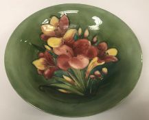 A Moorcroft shallow bowl decorated with lillies on a green ground 5.