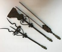 A set of three Continental wrought iron fire tools with brass putto handles comprising tongs,