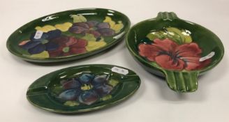 A collection of three pieces of Moorcroft comprising an oval green ground trinket dish 23 cm in