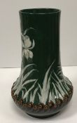 An early 20th Century pottery vase with pate sur pate decoration in white on a green ground of bird