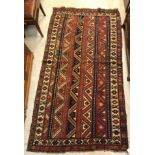 A vintage Caucasian carpet, the central panel set with striped design in blue, red and brown,