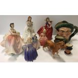 A collection of Royal Doulton figures and character jugs to include "Autumn Breezes", "The Polka",