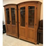 A pair of modern stained pine domed top part glazed two door cupboards or wardrobes with brass