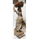 A late 19th Century Continental painted terracotta figure of a "Fisherwoman with basket on her head