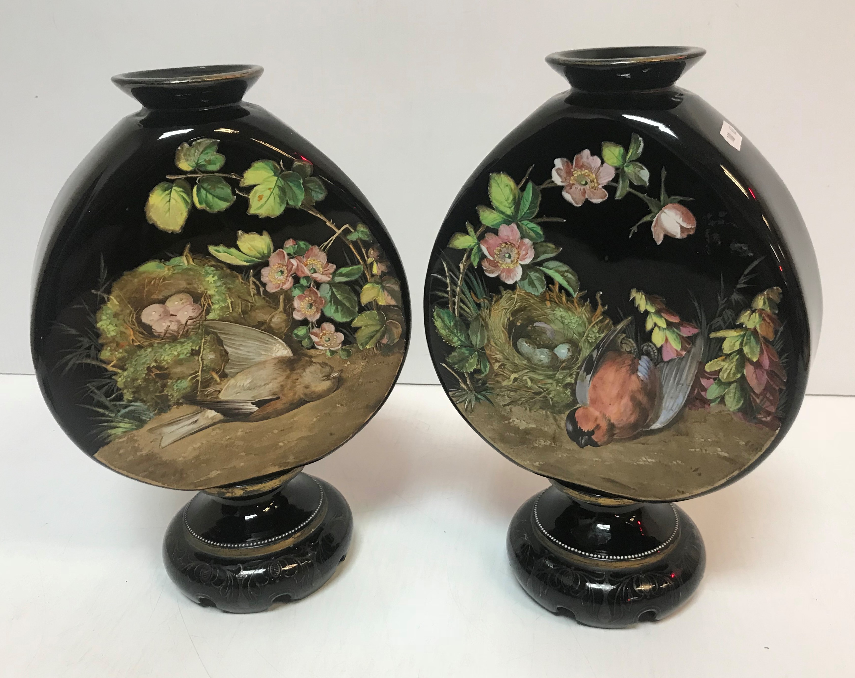 A pair of Victorian black glass vases with enamelled decoration depicting dead birds besides egg