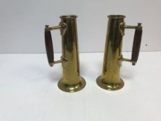 A pair of brass vases of cylindrical tapering form to flared circular base each set with a handle