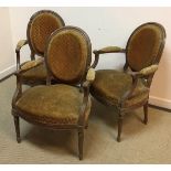 A set of three 19th Century French stained beech framed salon elbow chairs,