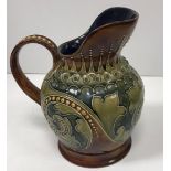 A Doulton Lambeth scrolling foliate relief work decorated jug on a brown ground,