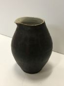 A Lucie Rie pouring vessel, with black glazed exterior and simple design,