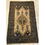 A Persian rug, the central panel set with lozenge shaped medallion on a cream ground,