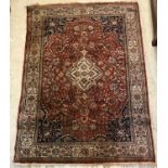 A Persian rug, the central panel set with floral decorated medallion on a brown ground,