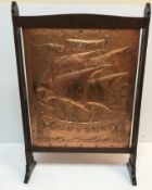 An Arts & Crafts beaten copper and oak framed fire screen,