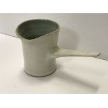 A Lucie Rie cream glazed pouring jug with side handle, with pale blue interior,