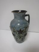 A Doulton Lambeth floral decorated jug on a pale blue ground, bearing initials “HBH”,