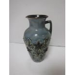 A Doulton Lambeth floral decorated jug on a pale blue ground, bearing initials “HBH”,