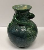 A C H Brannam Barum ware pottery vase of globular form with three scrolling handles decorated with
