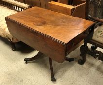 A Victorian mahogany drop leaf pembroke table with single end drawer opposite a dummy drawer on