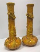Two Bretby yellow glazed pottery vases of onion form decorated in high relief with three toed