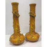 Two Bretby yellow glazed pottery vases of onion form decorated in high relief with three toed