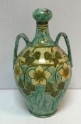 A Della Robbia twin handled vase decorated by Ruth Bare with foliate and flower decoration circa