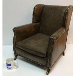 A circa 1900 buttoned leather upholstered wing back scroll arm child's chair on square tapered legs