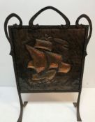 An Arts & Crafts fire screen, the embossed copper panel decorated with galleon in full sail,