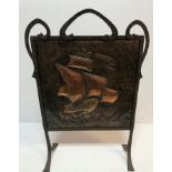 An Arts & Crafts fire screen, the embossed copper panel decorated with galleon in full sail,