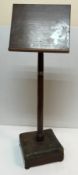 A mahogany adjustable music stand on a turned tapering pedestal to studded leather upholstered
