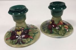 A pair of Moorcroft squat candlesticks,