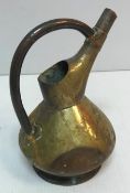 An early 20th Century brass water jug in the manner of Richard Perry,