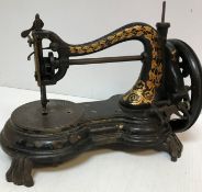 A Jones cast iron sewing machine with gilt decoration, raised on four scroll feet, 33 cm long x 19.