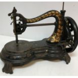 A Jones cast iron sewing machine with gilt decoration, raised on four scroll feet, 33 cm long x 19.