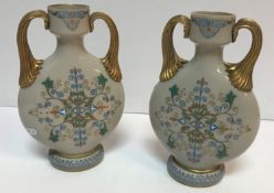 A pair of 19th Century Continental opaque twin handled glass vases with gilt and enamelled