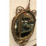 A 19th Century carved giltwood and gesso framed oval wall mirror in the Rococo taste,