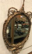 A 19th Century carved giltwood and gesso framed oval wall mirror in the Rococo taste,