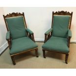 A pair of late Victorian stained beech framed and carved salon armchairs on turned front legs to