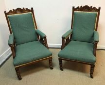 A pair of late Victorian stained beech framed and carved salon armchairs on turned front legs to