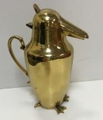 An Art Deco style brass jug as a penguin with scrollwork handle,