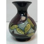 A Moorcroft squat baluster shaped vase with purple and green magnolia style flowers 13.