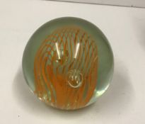 A modern paperweight with orange internal swirl decoration,