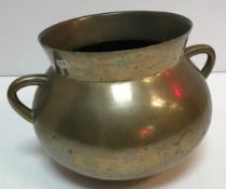 An 18th Century bronze twin handled cauldron of typical form 20 cm high